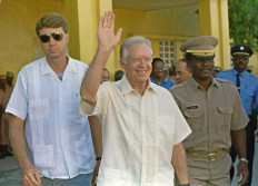 Former US President Jimmy Carter (center) waves after meeting 22 September 1990 in Port-au-Prince with authorities about the upcoming elections in Haiti. 