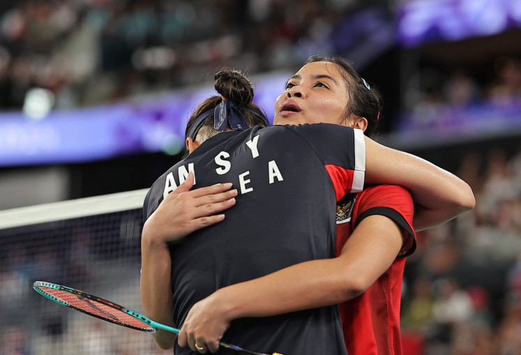 An Se-young of South Korea (left) hugs Gregoria Mariska Tunjung of Indonesia after winning their match in women's singles badminton semifinal during the Paris 2024 Olympic Games at Porte de la Chapelle Arena in Paris on Aug. 4, 2024.