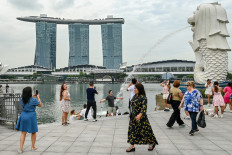 People gather next to the Merlion statue in front of the Marina Bay Sands resort in Singapore on Dec. 2, 2024.