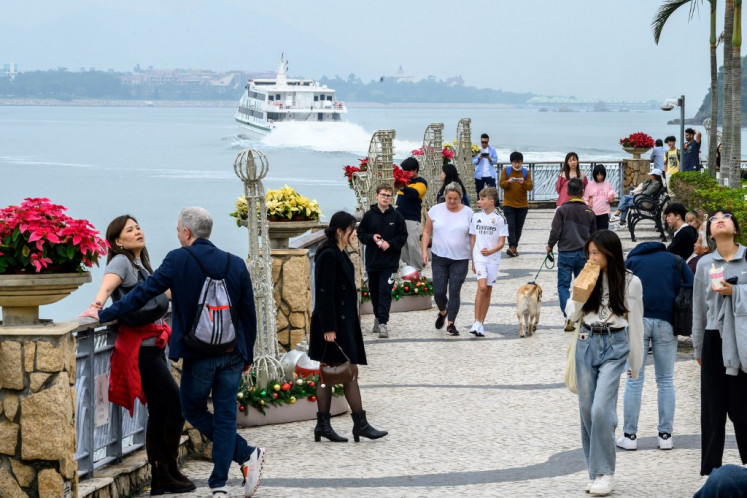 People walk on the seaside promenade at Discovery Bay on Lantau Island in Hong Kong, China, on Dec. 26, 2024.