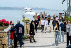 People walk on the seaside promenade at Discovery Bay on Lantau Island in Hong Kong, China, on Dec. 26, 2024.