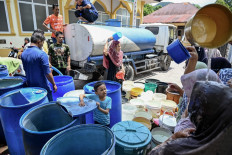 Women cool off from buckets filled with water supplied by the local officials amid the drought season in Lhoknga, Aceh on May 12, 2024.