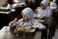 Students eat lunch as part of the free nutritious meals program on Jan. 6, 2025, at a school in Jakarta.