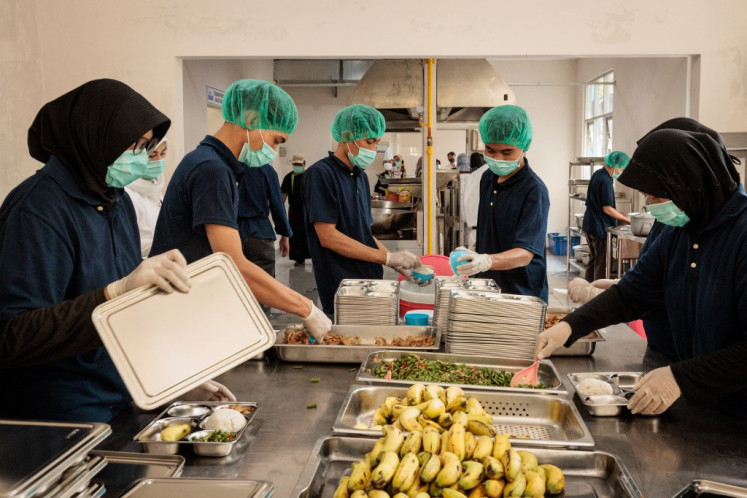 Staff prepare meals to deliver to a school at a kitchen on the first day of a free-meal programme in Jakarta on Monday, January 6, 2025. Indonesia launched an ambitious USD 4.3 billion free-meal programme on  January 6 to combat stunted growth due to malnutrition, a key election promise of President Prabowo Subianto.
