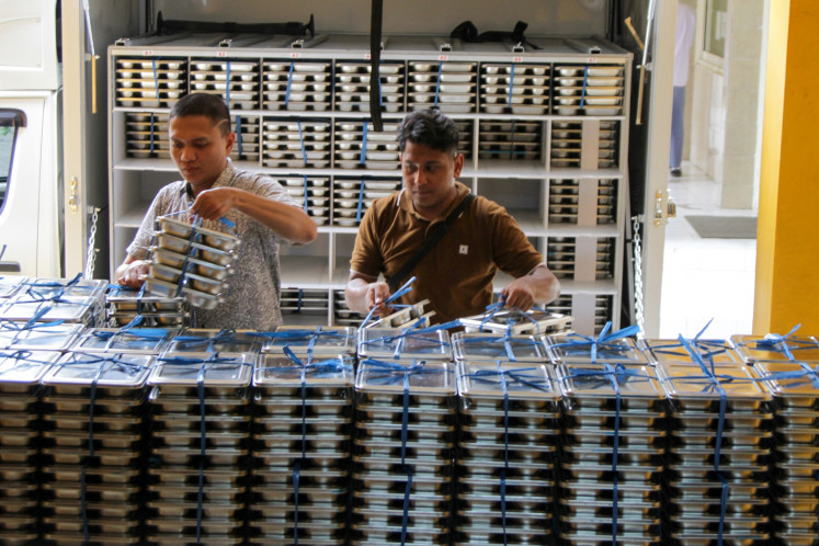 Rollout day: Workers prepare lunch trays for students of SMA Muhammadiyah 2 high school in Sidoarjo, East Java, on Jan. 6, the first day of the free nutritious meal program. Around 6,000 lunch packages were distributed across Sidoarjo that day as part of the free meals program, a key election promise of President Prabowo Subianto.