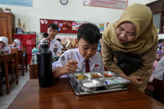 A student eats a packaged lunch on Jan. 6, 2025, the first day of the free nutritious meal rollout, at SDN Kranji 1 state elementary school in Purwokerto, Central Java. The ambitious program targeting schoolchildren and pregnant women was a key election promise of President Prabowo Subianto.