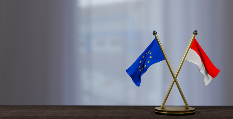 An illustration of Indonesian and European Union flags on a table.