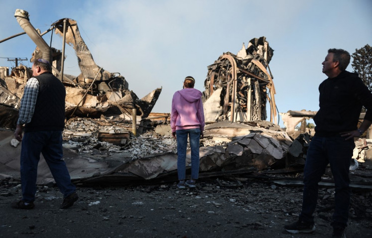 Pendeta John Shaver (kanan) melihat saat mengunjungi sisa-sisa Community United Methodist Church, di mana dia menjadi pendeta, ketika kebakaran hutan menyebabkan kerusakan dan kerugian di Los Angeles County pada 10 Januari 2025 di Pacific Palisades, California, Amerika Serikat. Pendeta Shaver berencana untuk membangun kembali gereja dan juga kehilangan rumahnya dalam kebakaran yang membakar seluruh Los Angeles County, yang dipicu oleh Angin Santa Ana yang kencang.