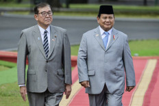 Indonesia's President Prabowo Subianto (R) and Japan's Prime Minister Shigeru Ishiba inspect the guard of honour at the presidential palace in Bogor, West Java, on Monday, January 11, 2025. 