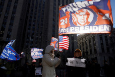 Supporters of United States president-elect Donald Trump hold a banner and flags on Jan. 10, 2025, the day of a sentencing hearing in the criminal case in which he was convicted in 2024 on charges involving hush money paid to a porn star outside of New York Criminal Court in Manhattan in New York City, the US.