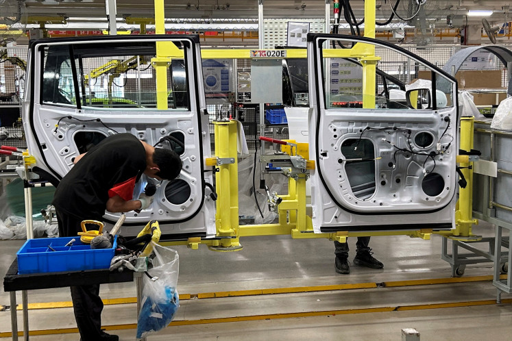 Employees work on an electric vehicle production line during an organized media tour to a factory under Jiangling Group Electric Vehicle (JMEV), in Nanchang, Jiangxi province, China, on May 22, 2024.