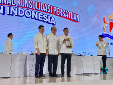 Officially resolved: Newly appointed Indonesian Chamber of Commerce and Industry (Kadin) chairman Anindya Bakrie (right) holds the Kadin report from outgoing Kadin chairman Arsjad Rasjid (left), accompanied by Kadin honorary council chair Rosan Roeslani, who led the national consolidation congress held at the Ritz-Carlton Mega Kuningan hotel in Jakarta on Jan. 16.