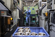 An employee works on an aluminum piston ring production line at a factory that produces car parts in Binzhou, in eastern China's Shandong province on Oct. 14, 2024.