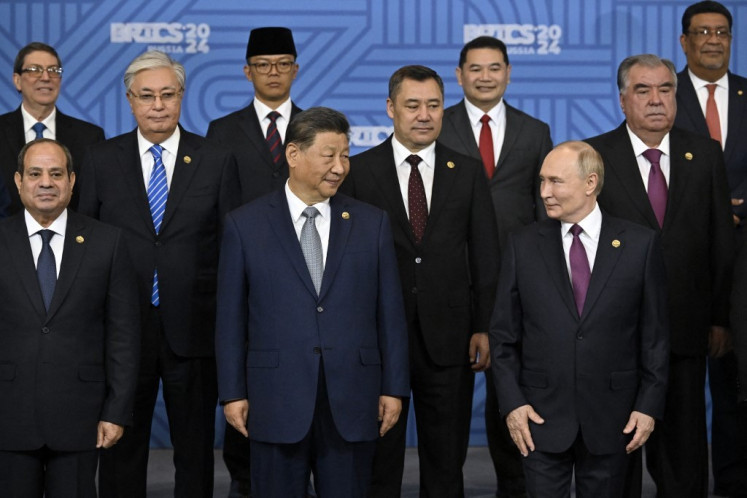 Foreign Minister Sugiono (rear, second left) poses for a group photo with (front, from left to right) Egyptian President Abdel Fattah al-Sisi, Chinese President Xi Jinping, Russian President Vladimir Putin and other participants in the outreach/BRICS Plus format meeting during the BRICS summit in Kazan, Russia on Oct. 24, 2024. (AFP/Alexander Nemenov/Pool)