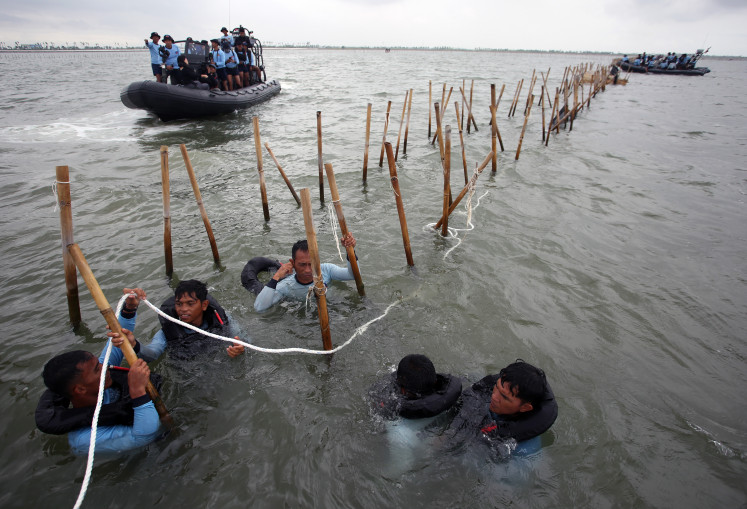 Members of the Navy's elite Frogmen Command (Kopaska) dismantles unlicensed sea fence in Tanjung Pasir beach area, Tangerang regency, Banten, on Wednesday, Jan. 22, 2025.