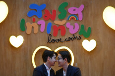 A couple poses for pictures at a marriage registration event at Paragon shopping mall in Bangkok on January 23, 2025. A high-profile gay couple married in Thailand on January 23 as the kingdom's same-sex marriage law went into effect. 