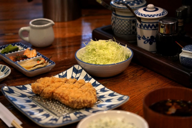 A pork cutlet dish served with shredded cabbage (center) at the restaurant Katsukichi in Tokyo on Jan. 21, 2025. The 2024 record summer heat and heavy rain ruined crops, driving up the cost of the usually inexpensive leafy green in what Japanese media has dubbed a “cabbage shock“.