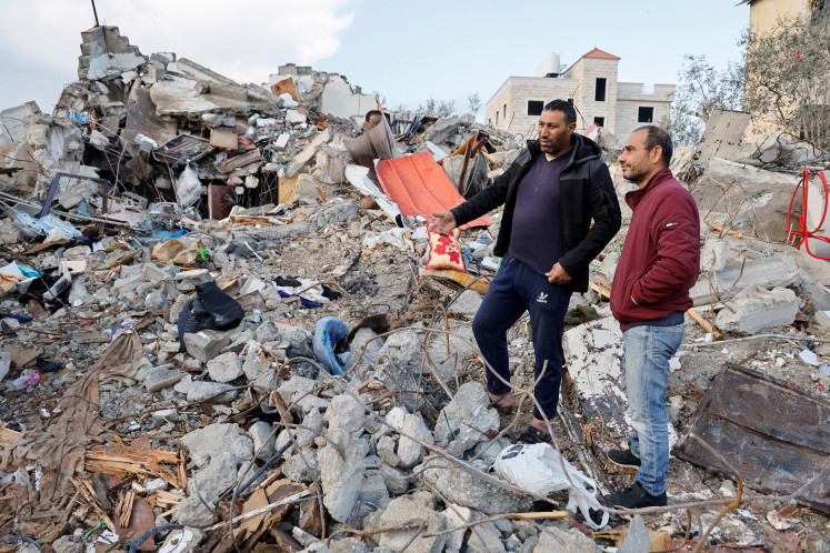 Palestinians inspect damaged property after two Palestinian gunmen were killed in an Israeli raid in Burqin in the Israeli-occupied West Bank on Jan. 23, 2025.