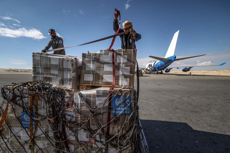 Workers handle boxes of the World Health Organisation (WHO) humanitian aid from a United Arab Emirates plane at Egypt's El-Arish airport on Jan. 24, 2025, as part of a mission organised by the UAE to deliver assistance in the Gaza Strip after a ceasefire deal in the war between Israel and Hamas.