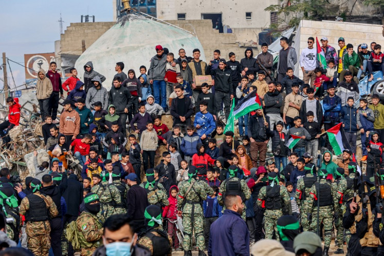 Orang Gaza berkumpul di alun -alun ketika para pejuang Hamas mengamankan daerah itu sebelum merilis empat sandera Israel ke tim Palang Merah di Gaza City pada 25 Januari 2025.