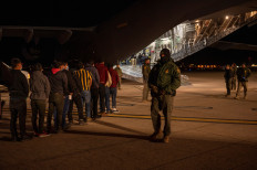 US Customs and Border Protection agents load detained migrants onto a US Air Force C-17 Globemaster III for a removal flight at the Tucson International Airport in Tucson, Arizona, US, on Jan. 23, 2025.