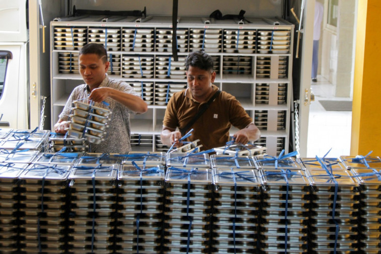Workers stack packaged lunches for students of SMA Muhammadiyah 2 high school in Sidoarjo, East Java, on Jan. 6, the first day of the free nutritious meals program. 