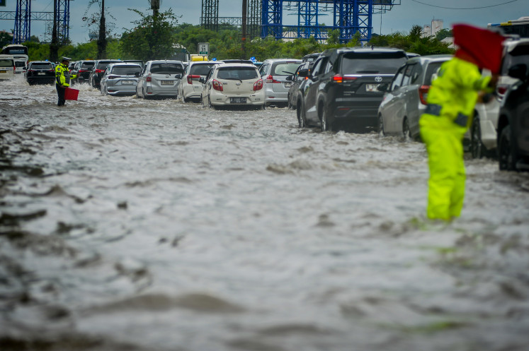 Police regulate vehicle traffic on Jan 29, 2025, during flooding on the Sedyatmo Toll Road, Cengkareng, Jakarta. The toll road, which is the access to Soekarno-Hatta Airport, was flooded 20-30 centimeters high due to the high intensity of rain. 
