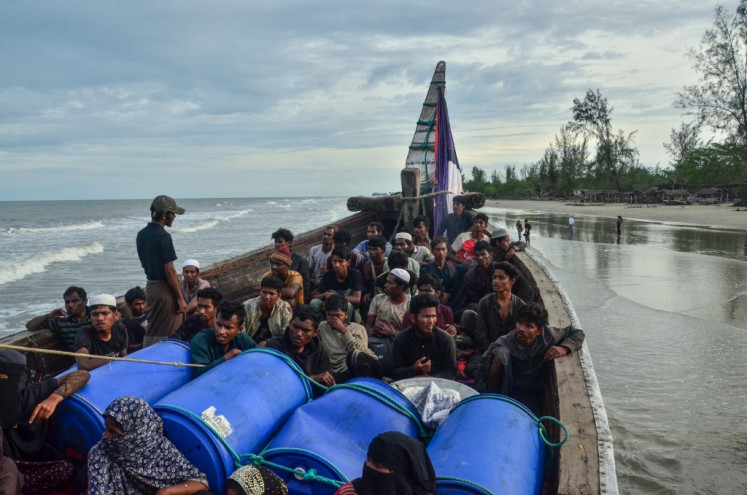 Newly-arrived Rohingya refugees look on from their boat after authorities prevented the refugees from disembarking and ordered them to remain on board the vessel at Leuge Beach in East Aceh regency, Aceh on Jan. 29, 2025. At least 75 Rohingya refugees arrived by boat at a beach in Aceh on Jan. 29, but were stopped by authorities from disembarking, according to local officials.