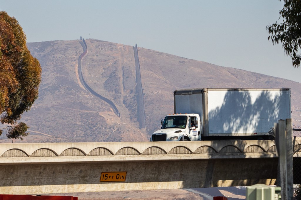 A truck drives into the United States with the US-Mexico border fence seen on the background at the Otay Mesa Port of Entry, on the US-Mexico border on Feb. 1, 2025, in San Diego, California.