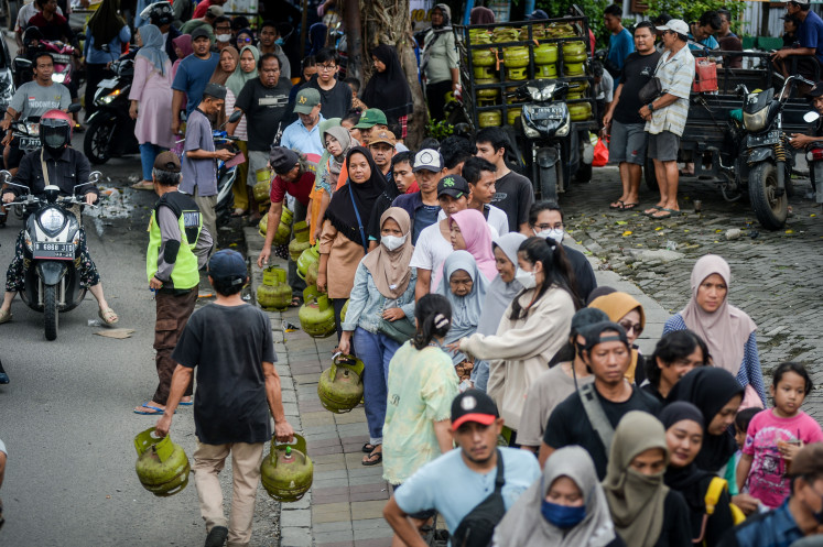 A crowd fills a sidewalk on Feb. 3, 2025, as they wait to exchange empty 3-kilogram canisters liquefied petroleum gas (LPG) at a distributor in Cibodas, Tangerang, Banten, following the government’s new policy banning retailers from selling the subsidized cooking gas.