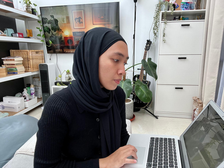 Being mindful: Ammar Fika Abdillah uses a laptop to review her financial spending in Depok, West Java, on Jan. 31, 2025.