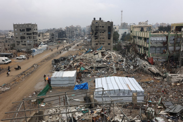 People walk amid collapsed buildings along the Saftawi street at Jabalia in the northern Gaza Strip on Feb. 5, 2025 during a ceasefire deal in the war between Israel and Hamas.