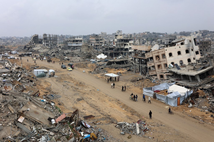 Devastated: People walk amid collapsed buildings along Saftawi street in Jabalia in the northern Gaza Strip on Feb. 5, 2025, during a ceasefire deal in the war between Israel and Hamas. Palestinian militant group Hamas lashed out on Feb. 5 at United States President Donald Trump's shock proposal for the US to take over the Gaza Strip and resettle its people in other countries, seemingly whether they wanted to leave or not.