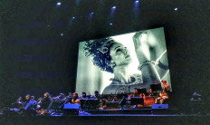 Stunning fusion: Juliet Widyasari Burnett dances on screen, while vocalists and gamelan musicians perform onstage during the media preview for 'Samsara' at the Graha Bhakti Budaya of Taman Ismail Marzuki in Cikini, Central Jakarta, on Dec. 13, 2024. Trained as a ballerina, Burnett also choreographed her dances for her scenes. 