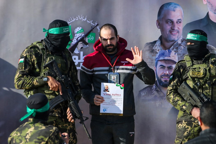 Palestinian militant group Hamas fighters escort Israeli hostage Yarden Bibas on a stage before handing him over to a Red Cross team in Khan Yunis on Feb. 1, 2025, as part of fourth hostage-prisoner exchange.