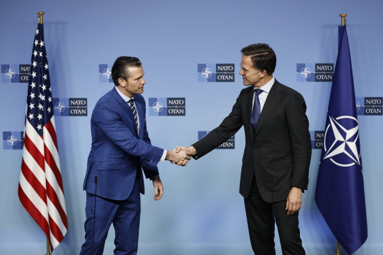 US Defense Secretary Pete Hegseth (left) and NATO Secretary General Mark Rutte shake hands prior to The North Atlantic Treaty Organisation (NATO) Ministers of Defense meeting at NATO Headquarters in Brussels, on February 13, 2025.