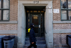 A man walks on Jan. 28, 2025, past an apartment entrance, where according to local media reports United States Immigration and Customs Enforcement (ICE) officers conducted an immigration raid in the Highbridge area of the Bronx borough of New York City. 
