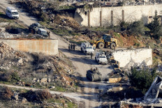 This picture taken from a position along Israel's northern border with Lebanon shows vehicles of the United Nations Interim Force in Lebanon (UNIFIL) and the Lebanese Army deploying in Lebanon's southern village of Odaisseh on February 18, 2025 amid destruction left by previous Israeli bombardments. Lebanon's army said it deployed in southern border villages and areas vacated by Israeli troops on February 18, as a withdrawal deadline expired under a truce between Israel and Hezbollah.  The ceasefire between Israel and the Iran-backed militant group has been in effect since November 27, following more than a year of hostilities, including two months of all-out war in which Israel launched ground operations. 