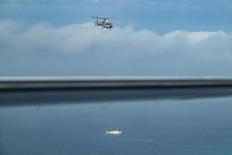 An aircraft identified by the Philippine Coast Guard as Chinese Navy helicopter (R) and a vessel identified by the Philippine Coast Guard as maritime militia (L) are seen during an aerial reconnaissance flight at Scarborough Shoal in the South China Sea on February 18, 2025.
