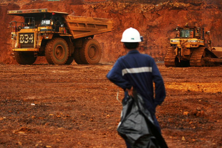 Resource sovereignty: A worker watches as trucks load up raw nickel on Jan. 8, 2014, near Sorowako, South Sulawesi.