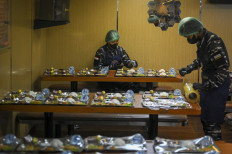 Indonesian Navy personnel prepares meal packages for the free nutritious meal program aboard the KRI Banda Aceh warship docked at the pier of the Military Naval Command (Kolinlamil) in North Jakarta on Jan. 23. 