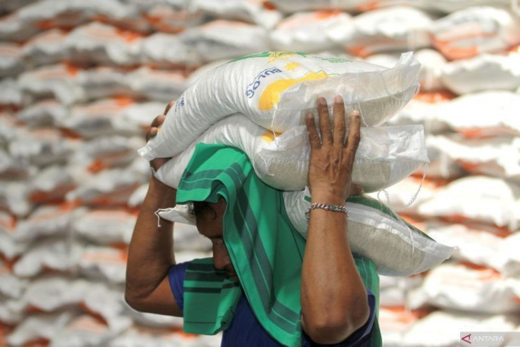 Shouldering the weight: A worker carries government rice aid at the warehouse of state-owned food logistics company, Bulog, in Talumolo village, Gorontalo city, Gorontalo, on March 3, 2024. (Antara/Adiwinata Solihin)

