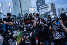 People demonstrate against President Prabowo Subianto's government, calling for reviews of government budget cuts and the free nutritious meals program, in front of a police barricade in Jakarta on Feb. 21, 2025.