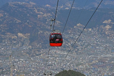 People ride a cable car over the Chandragiri hilltop, on outskirts of Kathmandu, Nepal on Feb. 3, 2025. They appear tranquil when soaring above Himalayan forests, but a string of cable car projects in Nepal have sparked violent protests with locals saying environmental protection should trump tourism development.