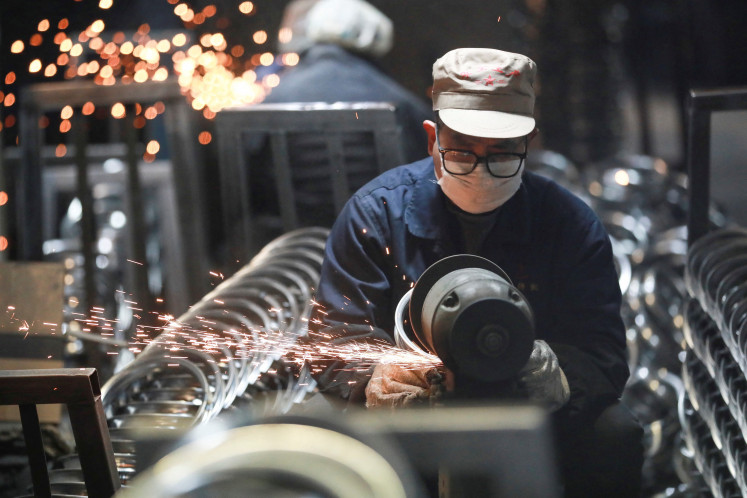 A worker processes stainless steel rings for bicycles for export at a factory in Hangzhou, in eastern China's Zhejiang province on Feb. 20, 2025.