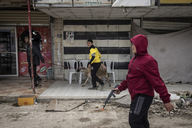 Palestinian children walk on a street by Israeli forces in the Jenin camp for refugees, in the occupied West Bank on February 24, 2025. Israel said on February 23 its troops would remain for many months in refugee camps in the northern West Bank, after tens of thousands of Palestinians living there were displaced by an intensifying, weeks-long military operation.