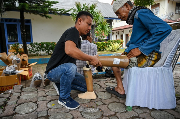 A technician helps a man put on a prosthetic limb donated by the government to mark the International Day of Persons with Disabilities on Dec. 3, 2024, in Banda Aceh, Aceh.