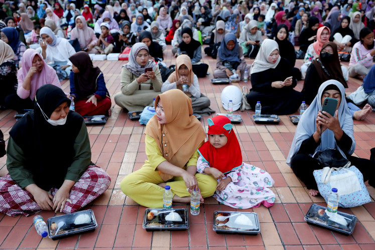 Muslim women wait to break their fast at Istiqlal Mosque during the Muslim holy month of Ramadan, in Jakarta, on March 1, 2025.