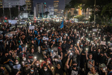  
Protesters light candles and flashlights on their cellular phones during a night-time protest near the Presidential Palace in Central Jakarta on Feb. 21, 2025. They demanded the government review budget cuts and the large allocation of funds to the free nutritious meal program for schoolchildren. 
