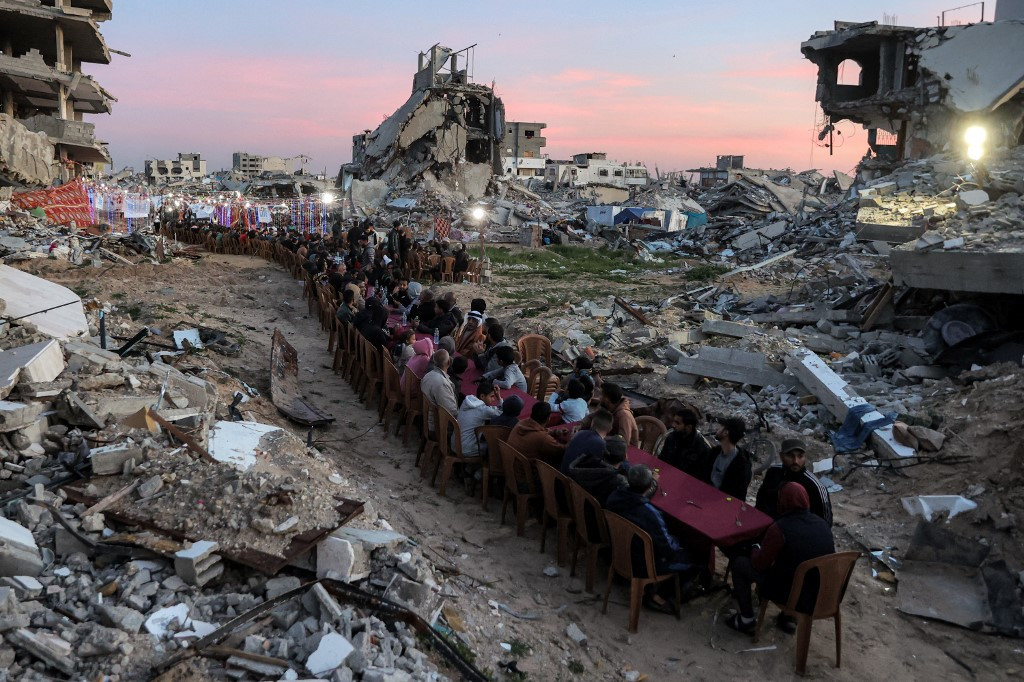 Meal among ruins: People gather near the rubble of destroyed buildings for a mass communal iftar fast-breaking meal on March 2, the second day of the Muslim holy month of Ramadan, in the area of al-Dahduh in Gaza City's Tal al-Hawa district, amid the truce in the war between Israel and Hamas.